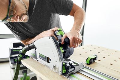 Човек с циркуляр на Festool реже дъска на многофункционална маса