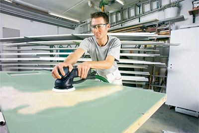 Мъж шлайфа зелена лакирана повърхност