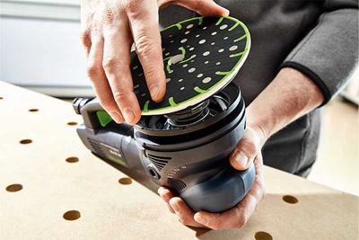Занаятчия поставя шлифовъчния диск на шлайфмашина Festool